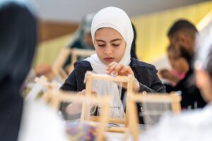 صغار "الشارقة الدولي للكتاب" ينسجون السجادة المغربية على الطريقة الأمازيغية 4 خ